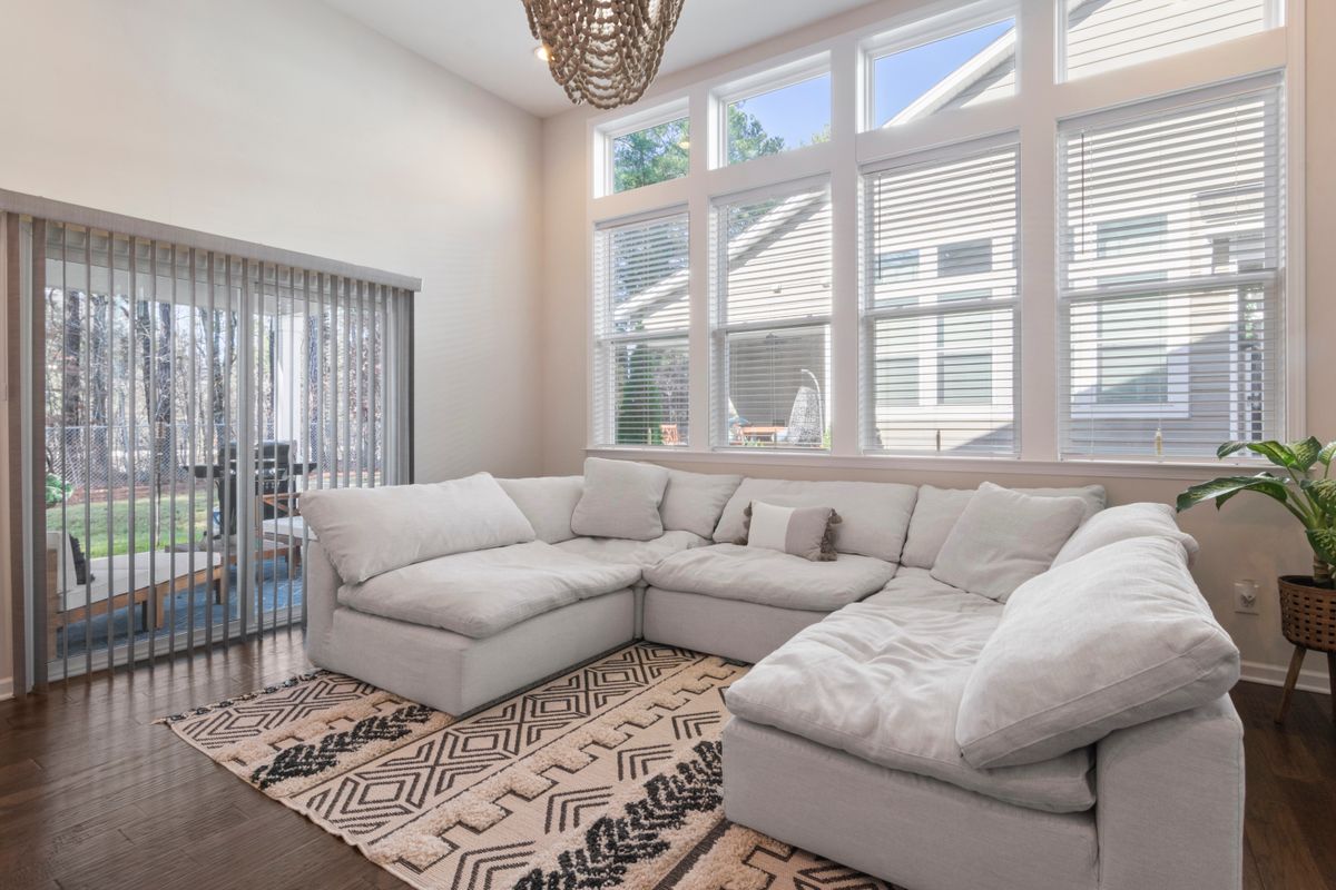 Open-plan living room with vertical blinds across the patio doors