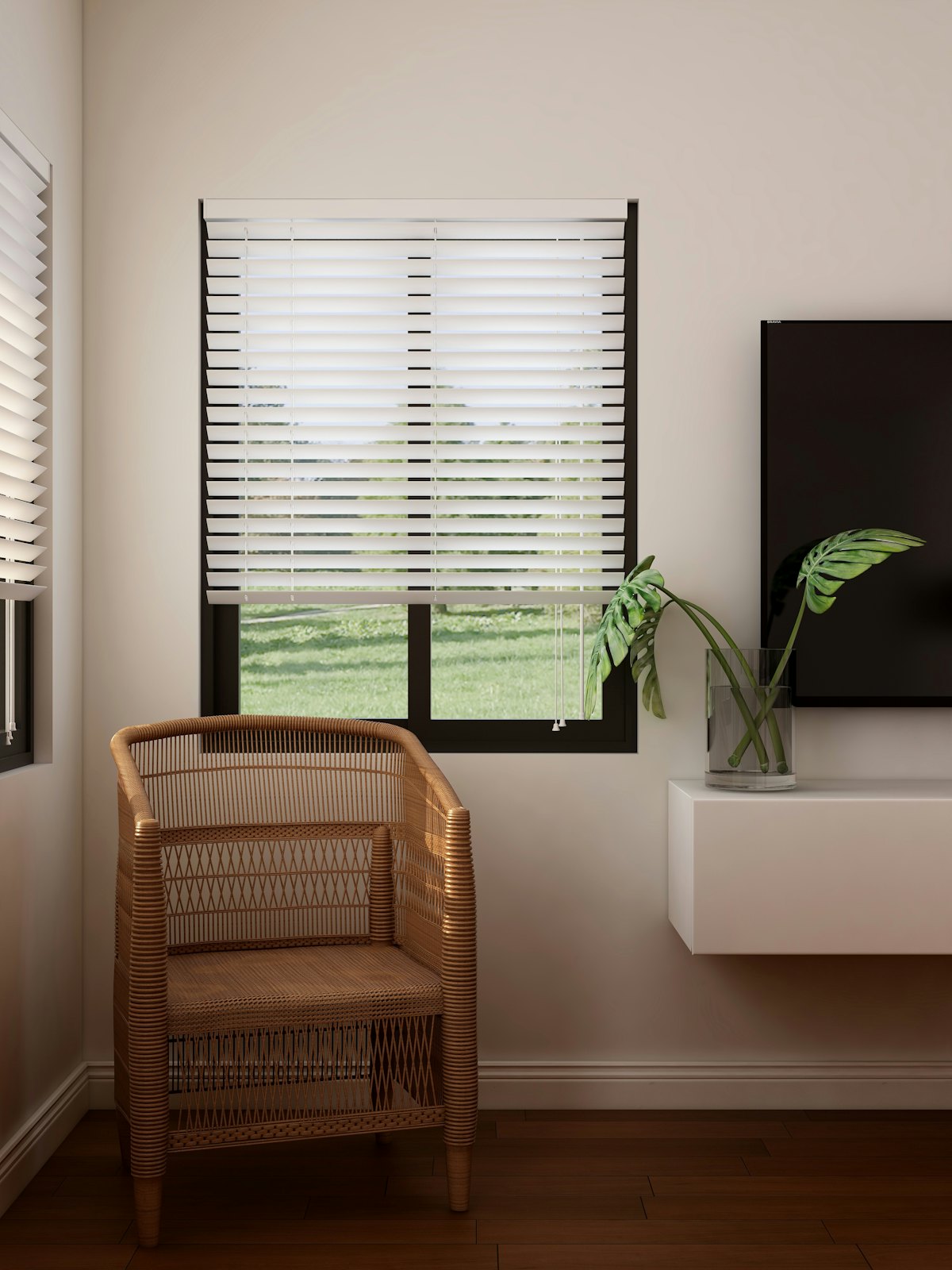 White faux wood venetian blind on a window beside a rattan chair